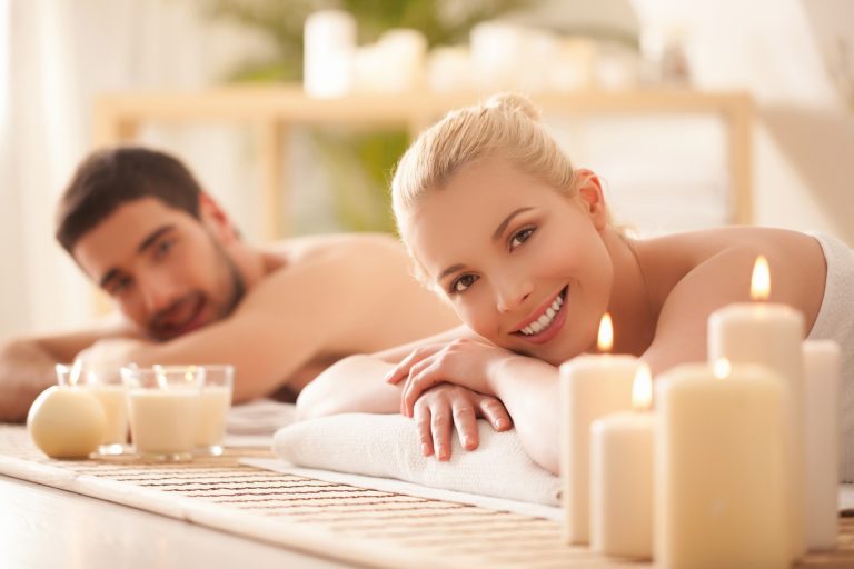 Young couple lying on the massage table and smiling.